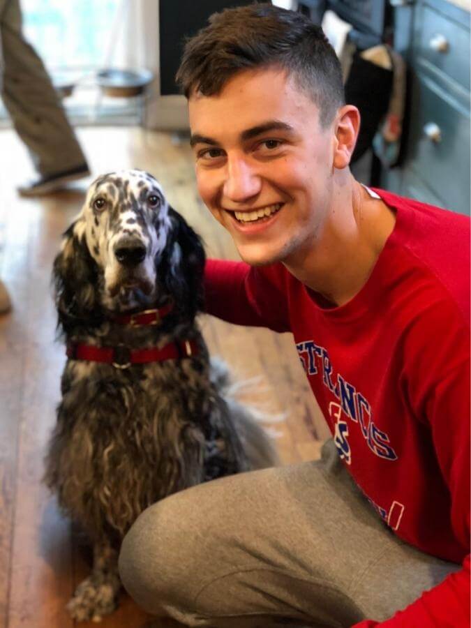 English Setter sitting next to a man posing for a picture