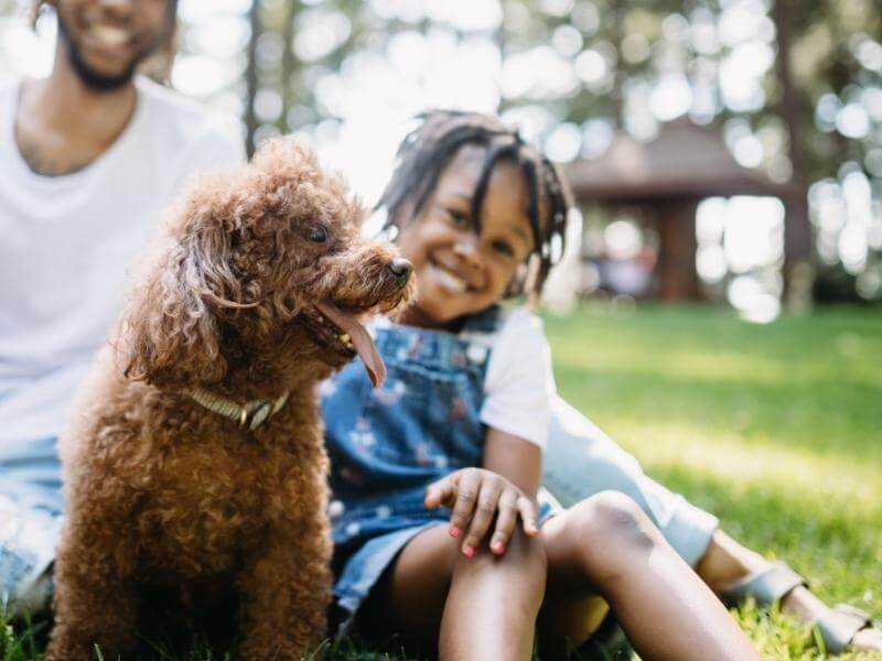 Father and daughter sitting outside with their dog